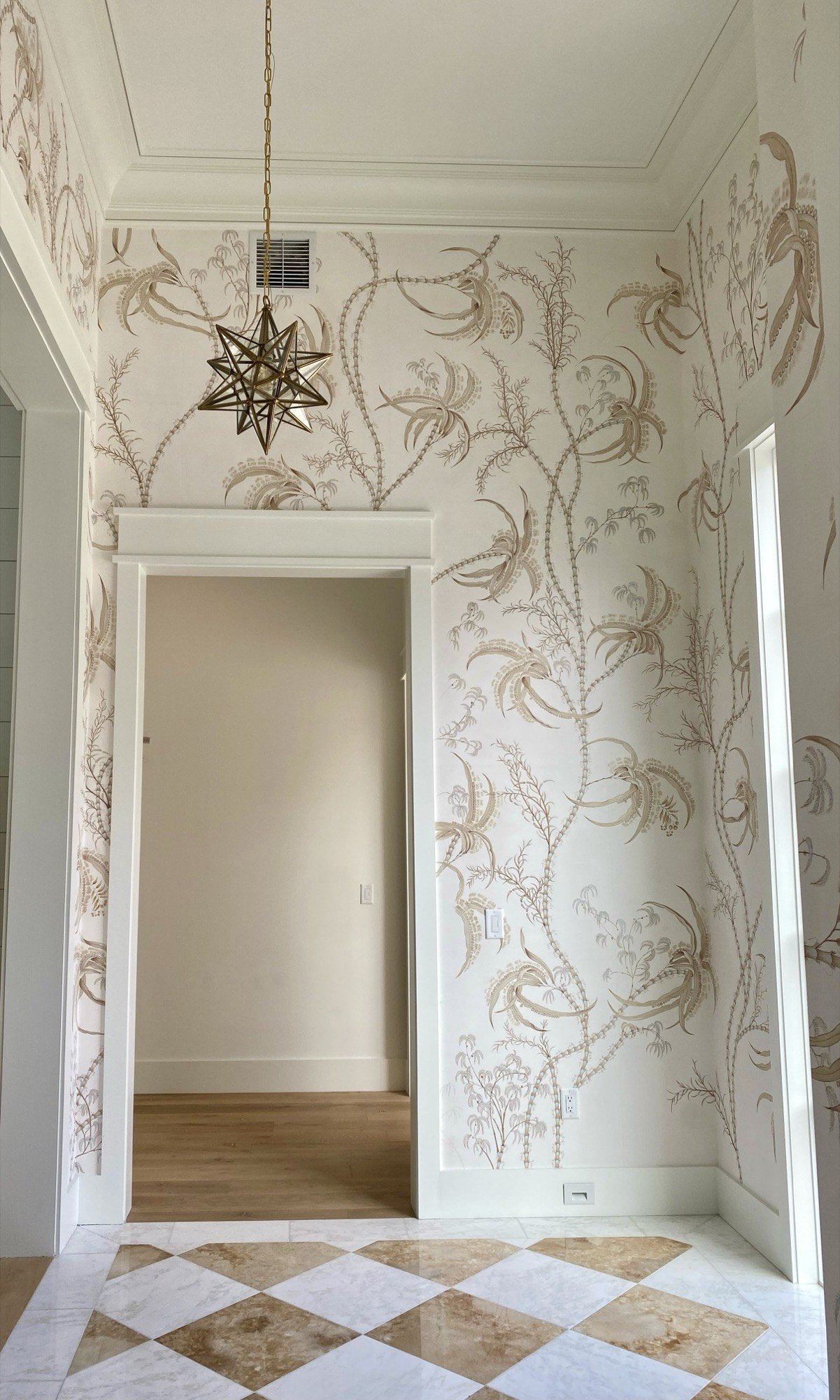Hand-painted grass cloth wallpaper with botanical fronds in an entry foyer with star pendant by Kim Delaney, Delaney Fine Finishes