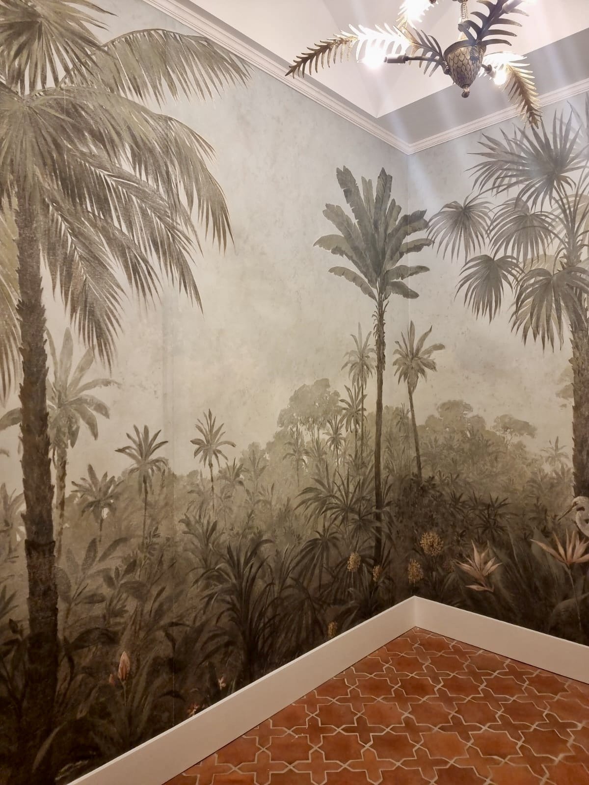 Corner of a hand-painted jungle mural powder room with palms by Kim Delaney, Delaney Fine Finishes