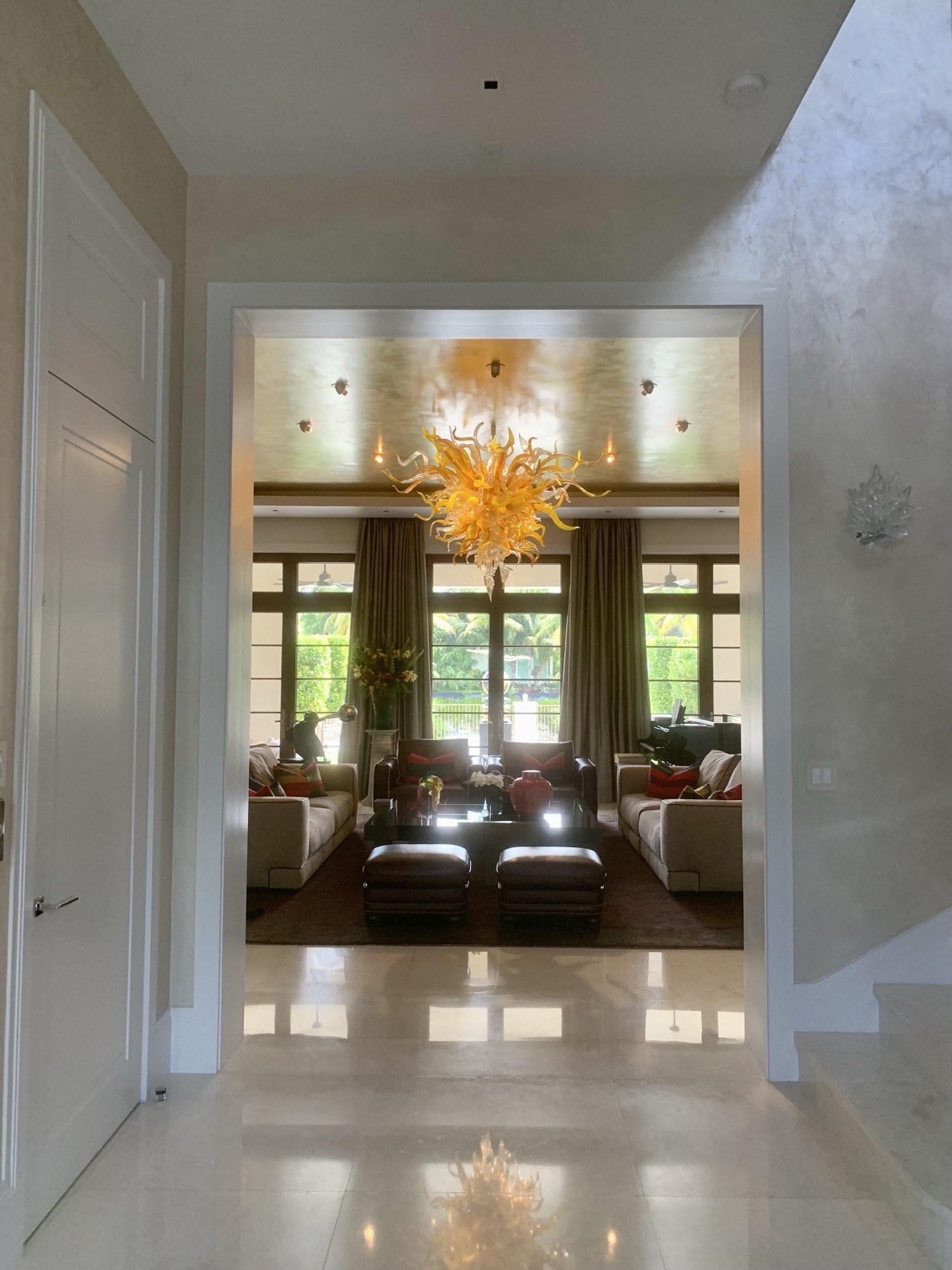 Polished plaster foyer opening to a living room with gold-leafed ceiling by Kim Delaney, Delaney Fine Finishes