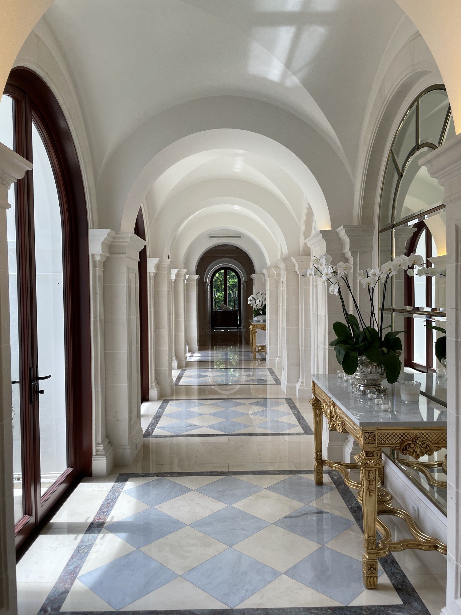 Vaulted gallery hallway in polished plaster with arches and marble floor by Kim Delaney, Delaney Fine Finishes