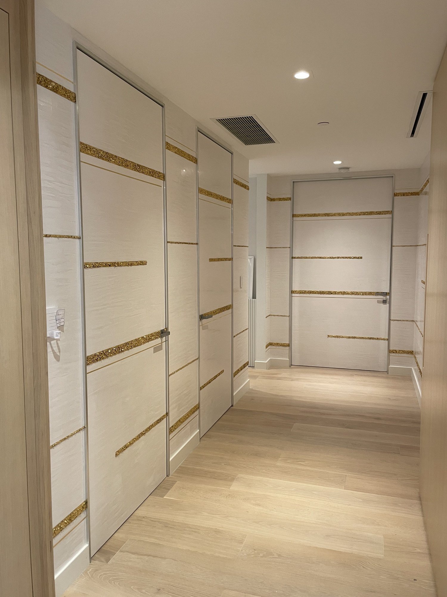 Hallway of textured plaster panels with gold-leaf inlay bands by Kim Delaney, Delaney Fine Finishes